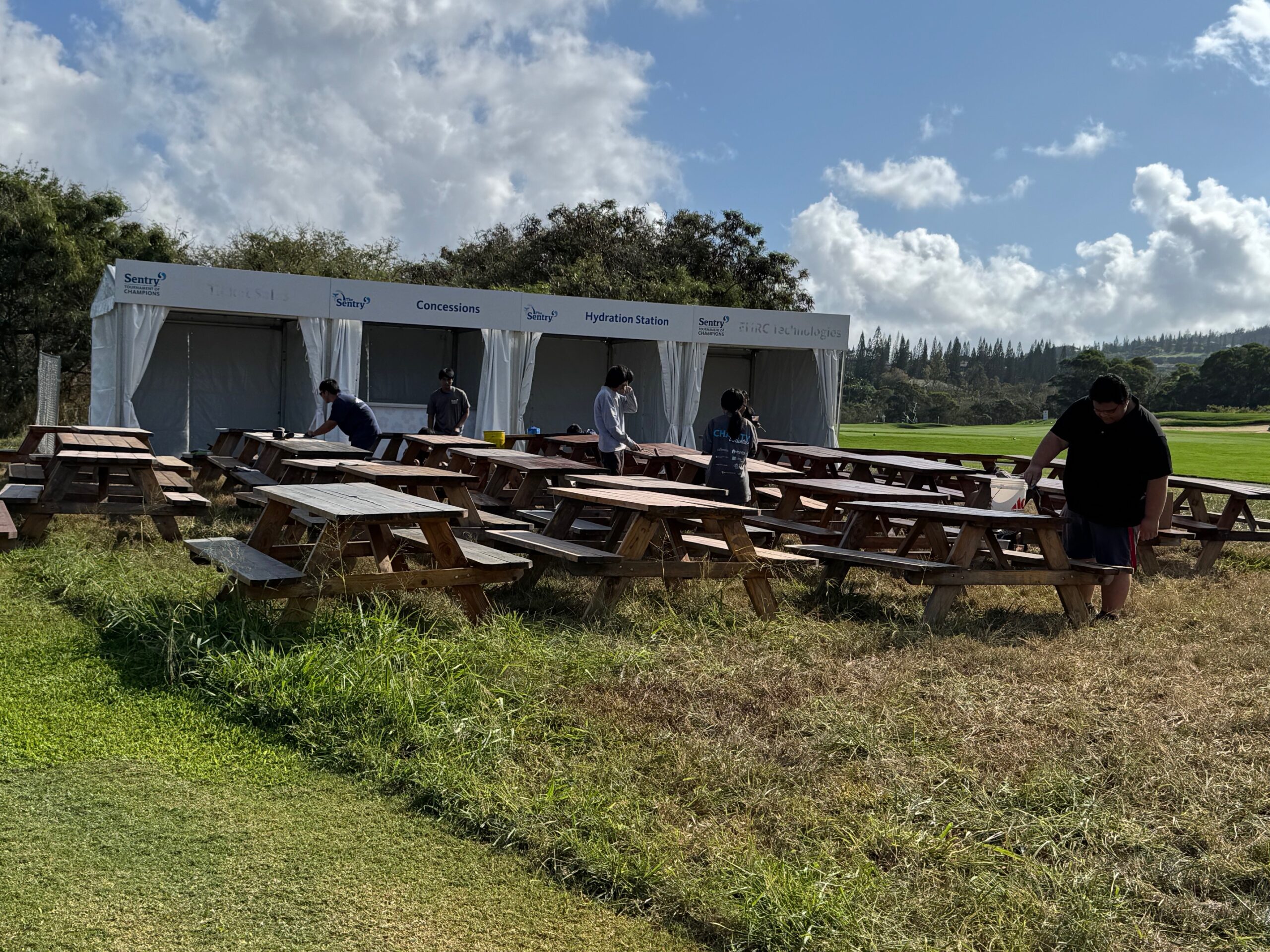 Lahainaluna High School students paint picnic tables prior to The Sentry golf tournament at the Kapalua Plantation Course in December 2024. HJI / ROB COLLIAS photo