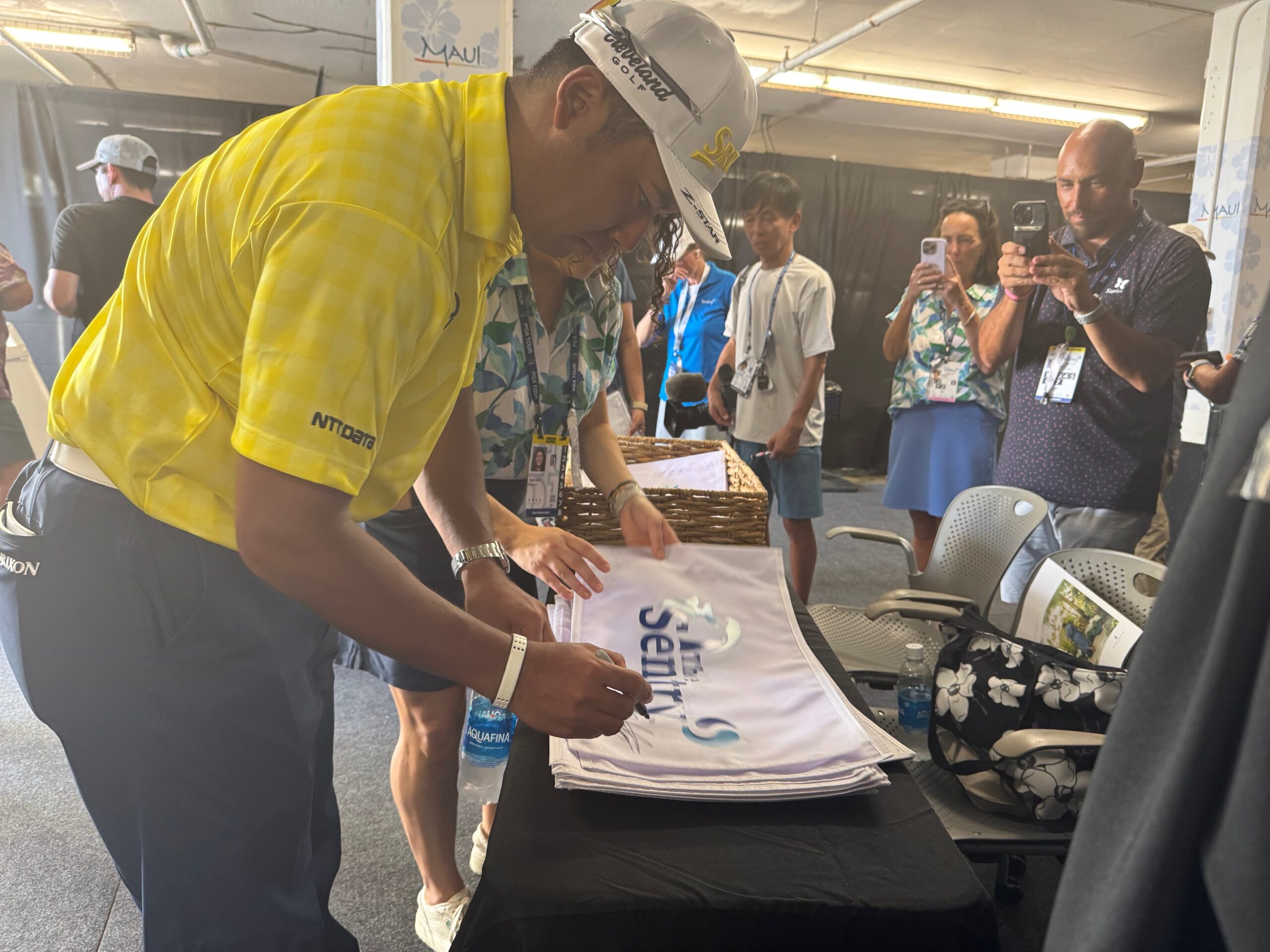 Hideki Matsuyama signs flags after The Sentry golf tournament at the Kapalua Plantation Course on Sunday. Matsuyama shot a PGA Tour record 35-under par to claim $3.6 million of the $20 million purse. HJI / ROB COLLIAS photo