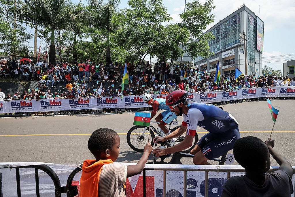 Mongolian rider Tegshbayar Batsaikhan (L) and French rider Julian Alaphilippe (R) competes in the men's Elite road race cycling event during the UCI 2025 Road World Championships, in Kigali, on September 28, 2025. (Photo by Anne-Christine POUJOULAT / AFP)