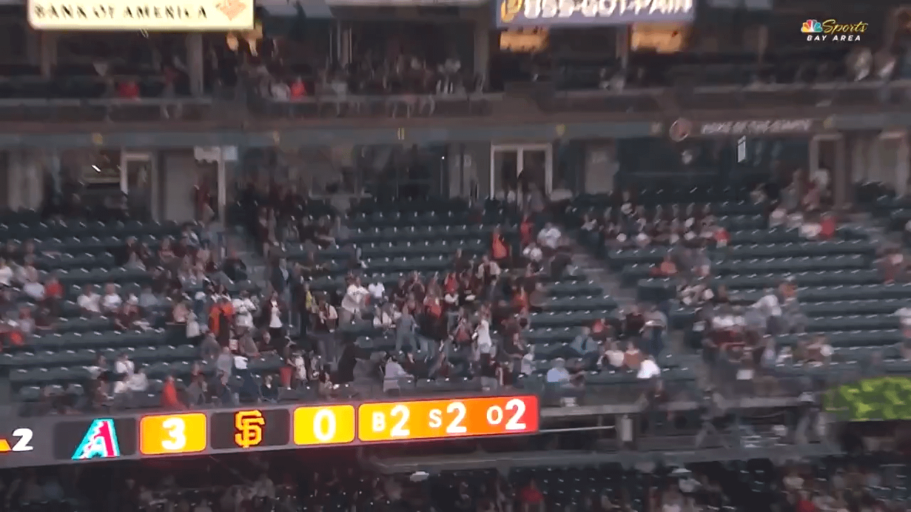 Adult San Francisco Giants fan catches ball in stands and gives to young fan near him