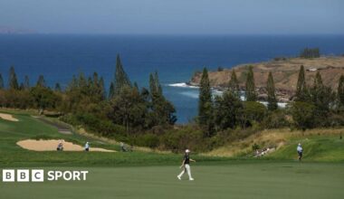 Hideki Matsuyama holding The Sentry trophy.