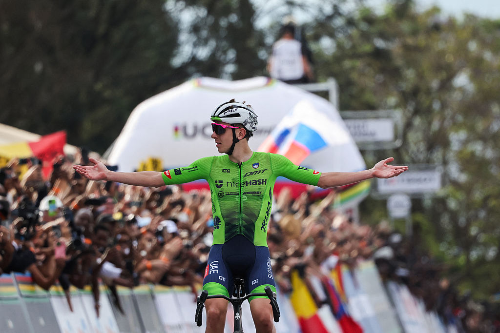 Slovenian rider Tadej Pogacar celebrates as he crosses the finish line to win the men's Elite road race cycling event during the UCI 2025 Road World Championships, in Kigali, on September 28, 2025. (Photo by Anne-Christine POUJOULAT / AFP)