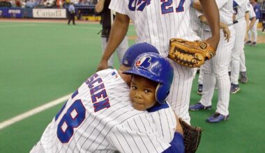 Young Vladimir Guerrero Jr. on the Olympic Stadium field with his father and other Expos