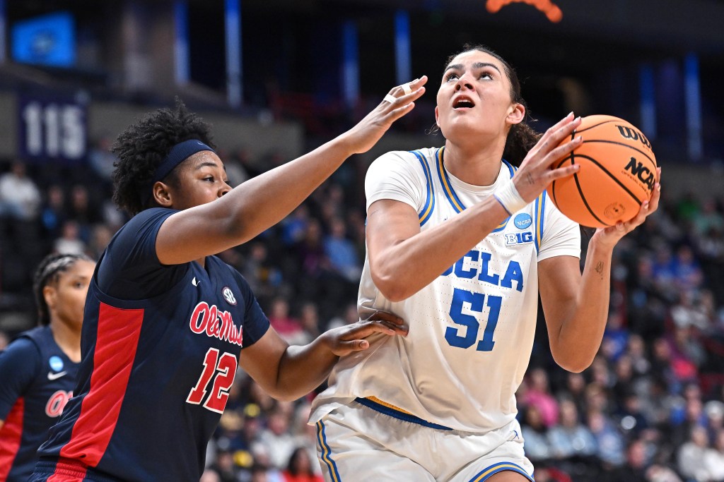 UCLA center Lauren Betts looks up at the basket as she prepares to shoot over Mississippi forward Christeen Iwuala. Iwuala extends her right arm to try to deter or contest the shot.