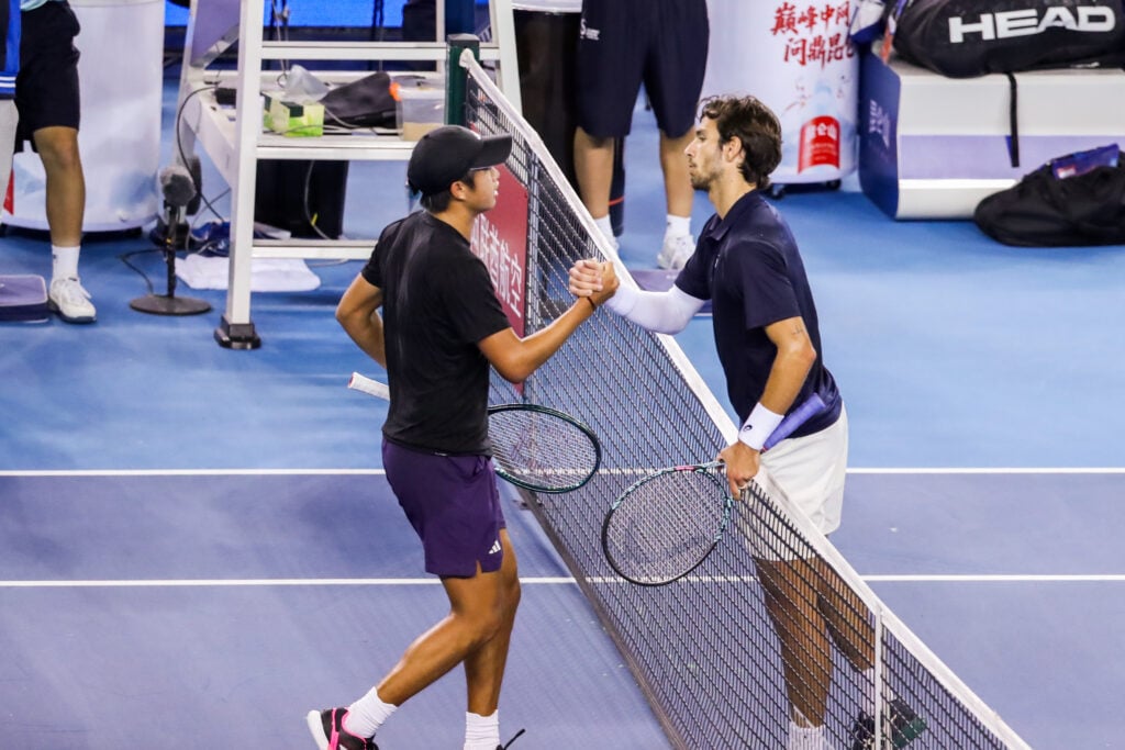 Learner Tien and Lorenzo Musetti meet at the net at the China Open.
