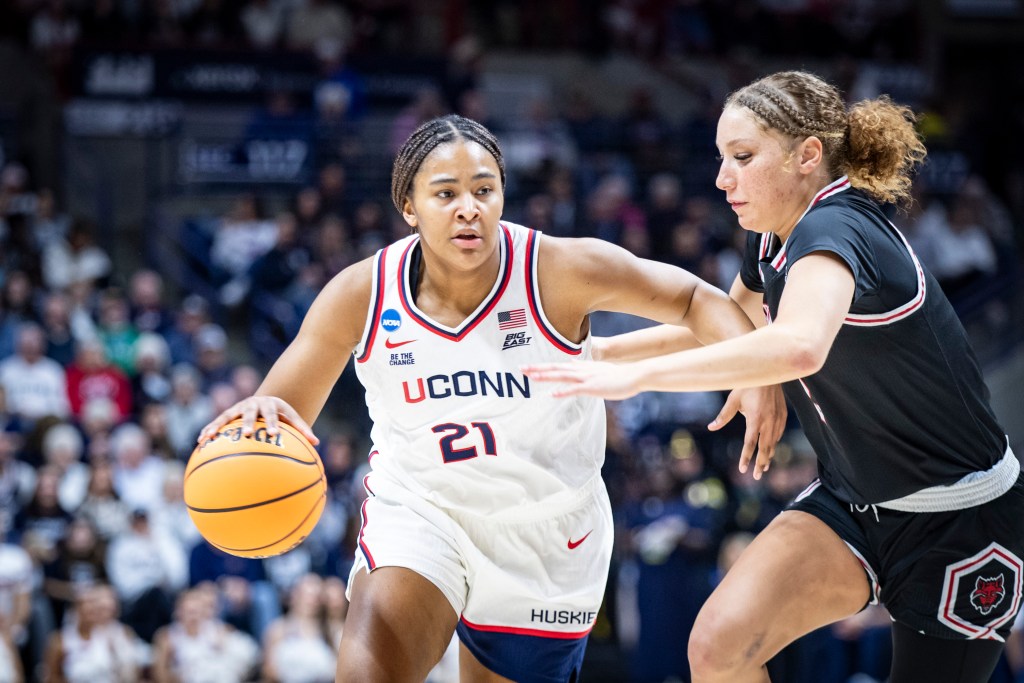 UConn forward Sarah Strong dribbles the ball with her right hand. She uses her left hand to try to hold off a defender looking for a steal.