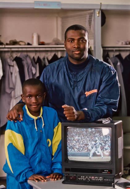 Tony Gwynn and Tony Gwynn Jr. stand next to a portable TV and VCR he used to review televised at-bats. Gwynn was the first player to regularly review game footage; Pioneering a method that’s now standard for players everywhere.