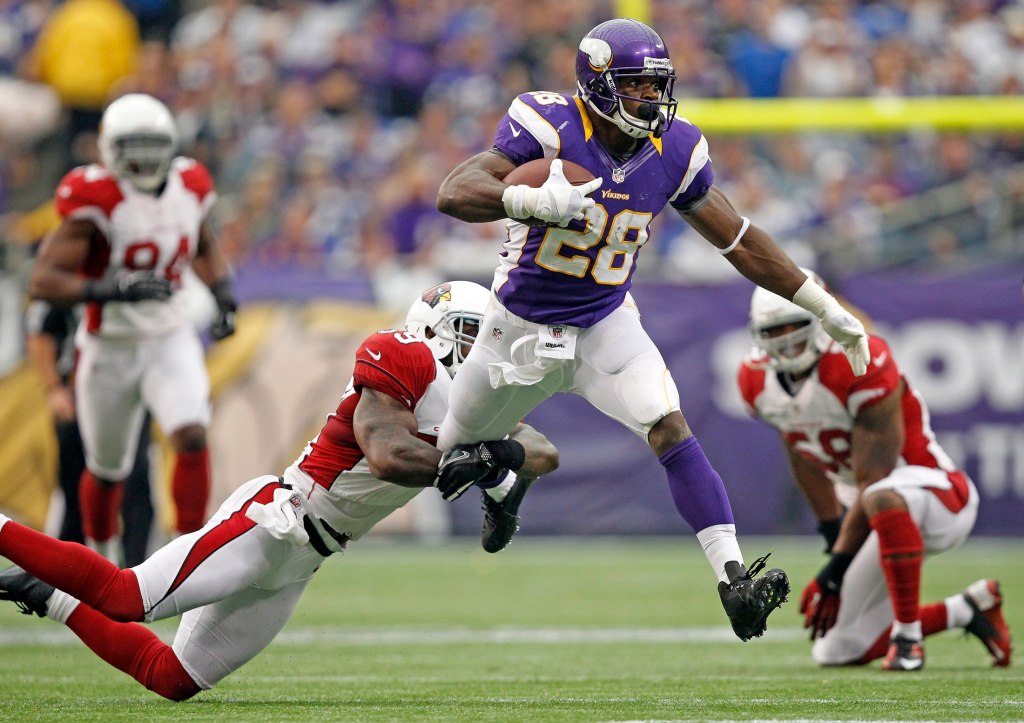 Minnesota Vikings running back Adrian Peterson is tackled by Arizona Cardinals safety James Sanders.