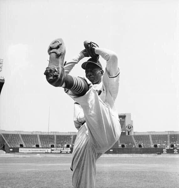 Satchel Paige in to his windup with a high leg kick at Cleveland Municipal Stadium in 1948. In his 1948 season with Cleveland, he went 6-1 with a 2.48 ERA and helped the team win the American League pennant and the World Series, becoming the first African-American to pitch in a World Series game.