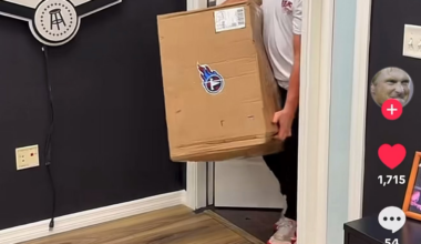 Jon Gruden opening a box of goods sent from the Tennessee Titans.