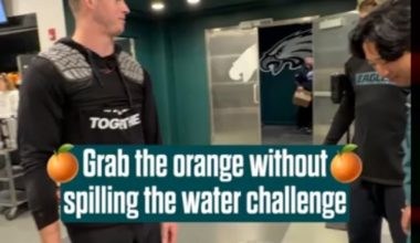 Eagles players try to remove an orange from a cup without spilling water