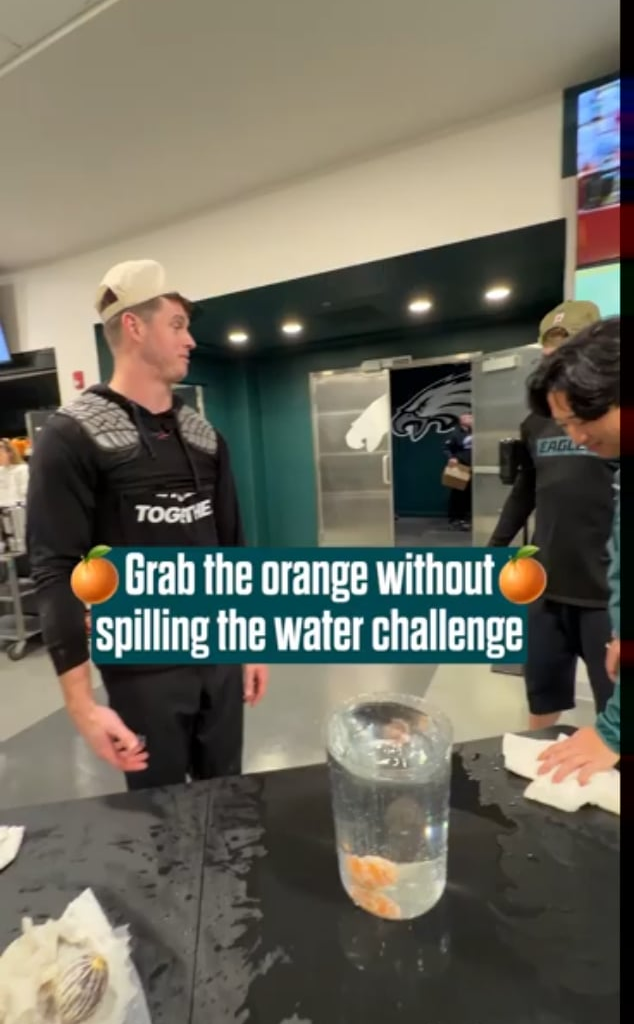 Eagles players try to remove an orange from a cup without spilling water