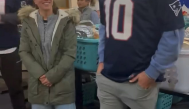 Drake Maye and his wife, Ann Michael, help carry donated Thanksgiving food and goods to the cars of families in need in Boston