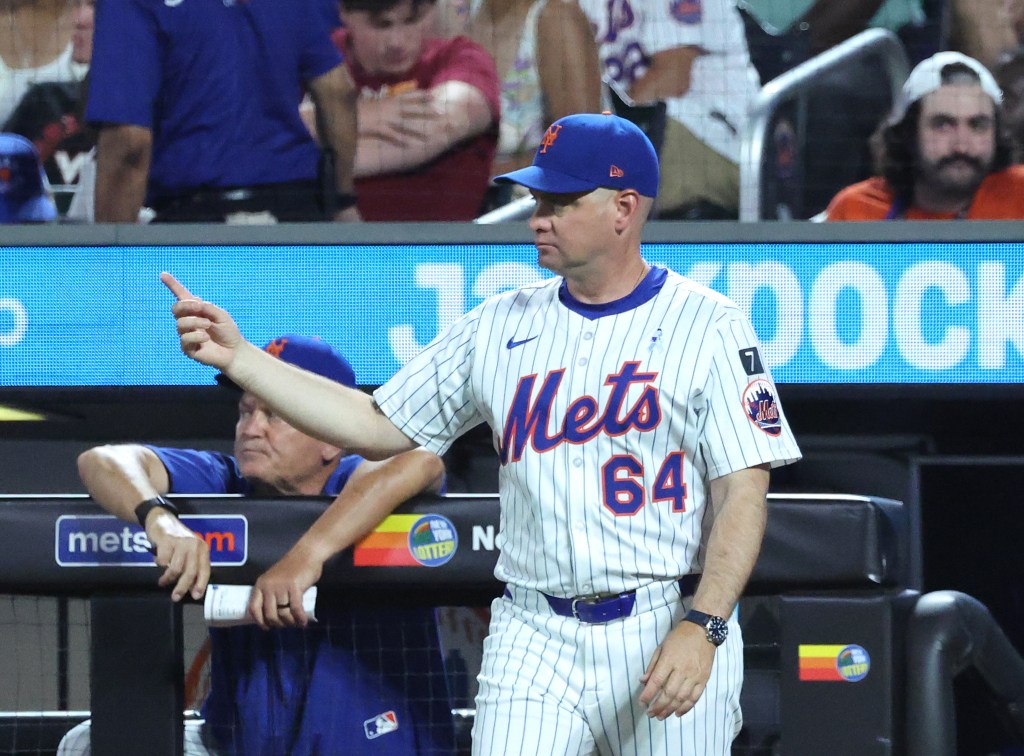 New York Mets manager Carlos Mendoza #64 signals for a new pitcher during the 6th inning.