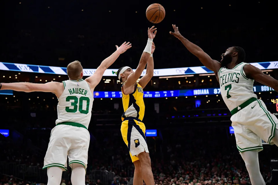 Dec 29, 2024; Boston, Massachusetts, USA; Indiana Pacers guard Andrew Nembhard (2) shoots the ball between Boston Celtics forward Sam Hauser (30) and Boston Celtics guard Jaylen Brown (7) during the second half at TD Garden. Mandatory Credit: Bob DeChiara-Imagn Images
