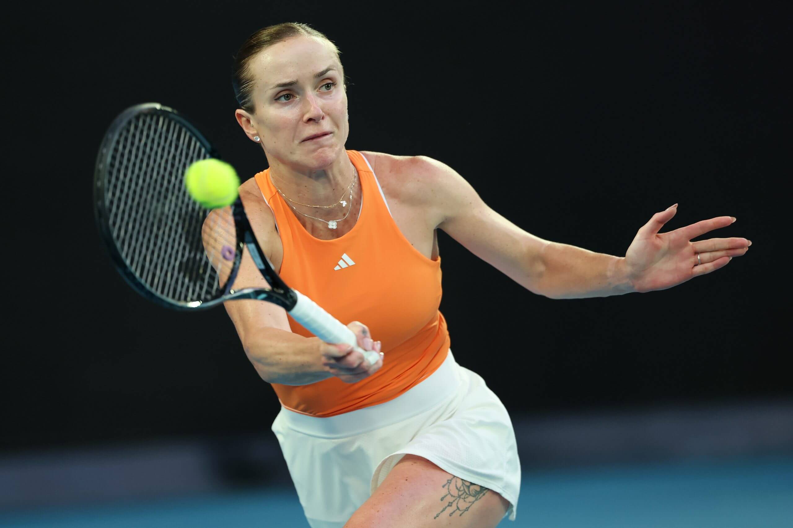 Elina Svitolina stretches for a forehand with the ball on her racket.