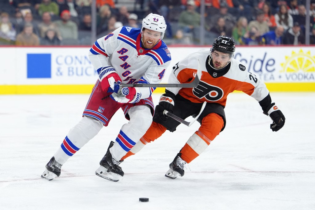 New York Rangers player against Philadelphia Flyers player during an NHL game.