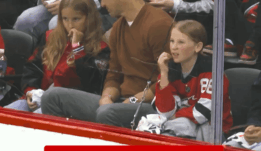 Eli Manning tells his daughters not to flinch when the puck hits the glass and he then immediately does it when it happens.