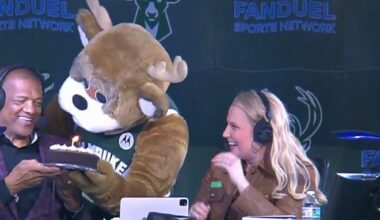 Bango presenting Marques Johnson with a birthday cake in the broadcast booth