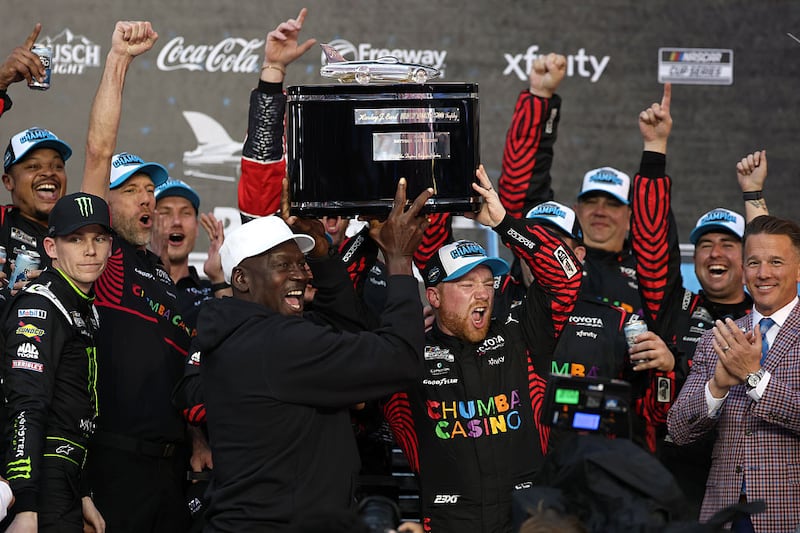 Tyler Reddick, driver of the #45 Chumba Casino Toyota, and Michael Jordan, NBA Hall of Famer and co-owner of 23XI Racing lift the Harley J. Earl Trophy in victory lane after winning the NASCAR Cup Series Daytona 500