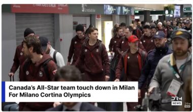 Media/Security guy in a Canucks hat escorting the Team Canada players