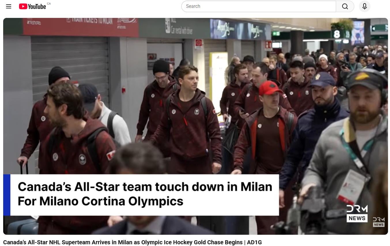 Media/Security guy in a Canucks hat escorting the Team Canada players