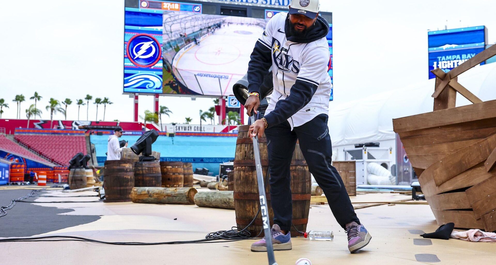 Cammy playing hockey with a baseball as a puck in a football stadium