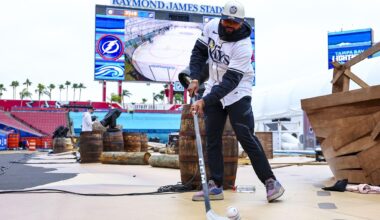 Cammy playing hockey with a baseball as a puck in a football stadium