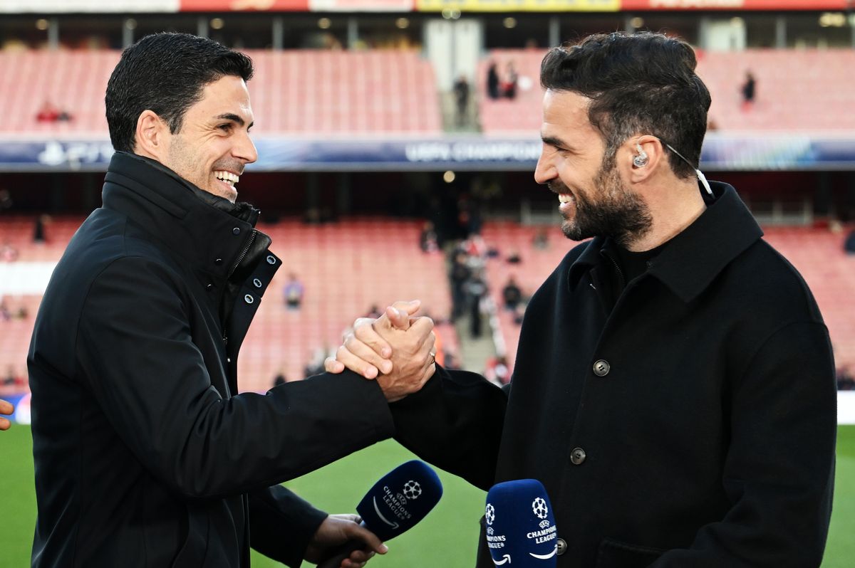 Mikel Arteta, Manager of Arsenal, shakes hands with Cesc Fabregas during a pitch-side interview prior to the UEFA Champions League 2024/25 Quarter Final First Leg match between Arsenal FC and Real Madrid