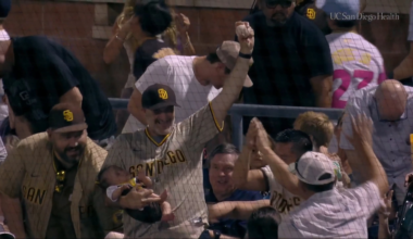 Fan makes a nifty bare-handed catch while holding a sleeping baby