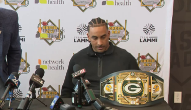Jordan Love ends his Charity Softball game presser by taking the championship belt and hitting a discount double check