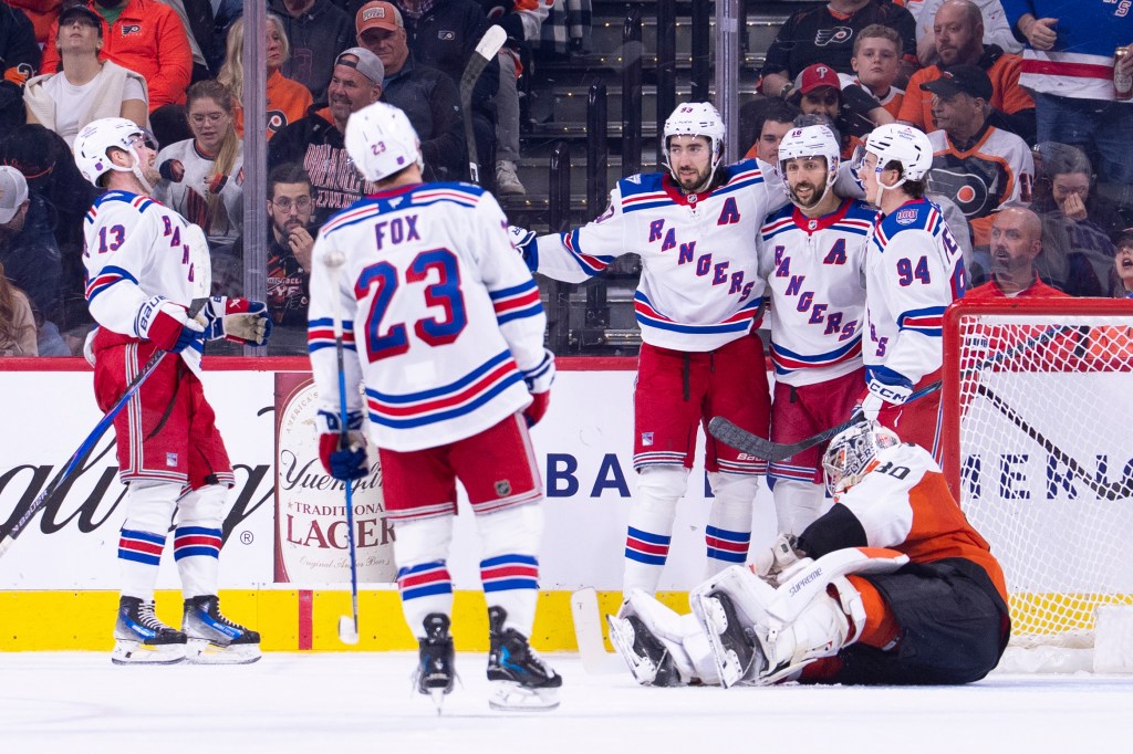 Mika Zibanejad, Adam Fox, Gabe Perreault, and Alexis Lafreniere of the New York Rangers celebrate a goal against Dan Vladar of the Philadelphia Flyers.