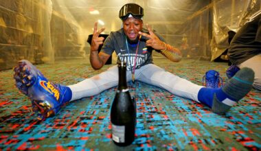 Ronald Acuña Jr. celebrating Venezuela's World Baseball Classic title by himself in the clubhouse, using a champagne bottle to prop his phone up