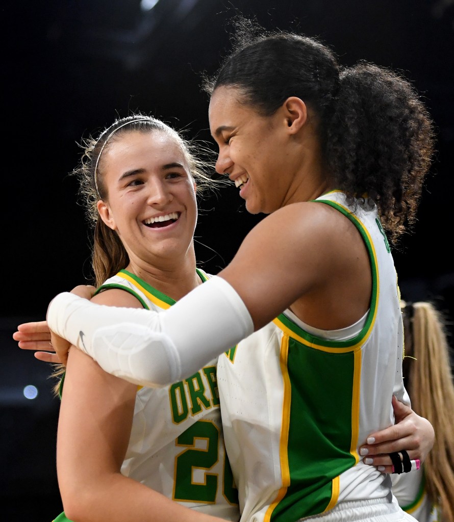 Sabrina Ionescu #20 and Satou Sabally #0 of the Oregon Ducks hug as they come out of the game late in their 89-56 victory over the Stanford Cardinal during the championship game of the Pac-12 Conference women's basketball tournament at the Mandalay Bay Events Center on March 8, 2020.
