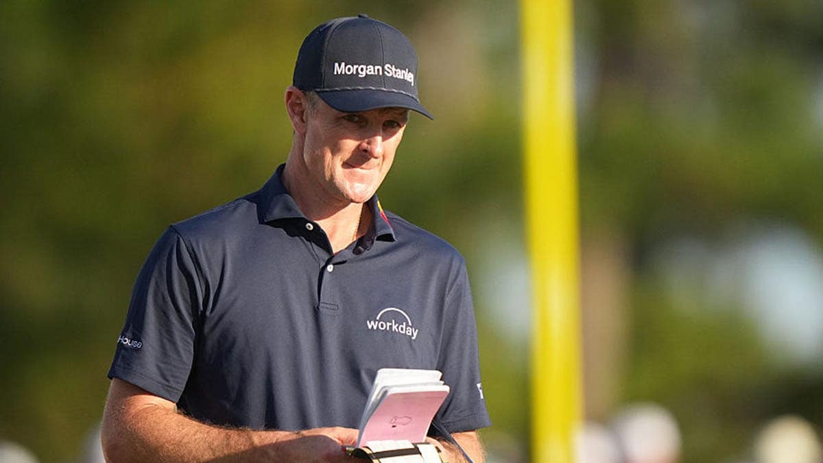 Justin Rose walks with his scorecard