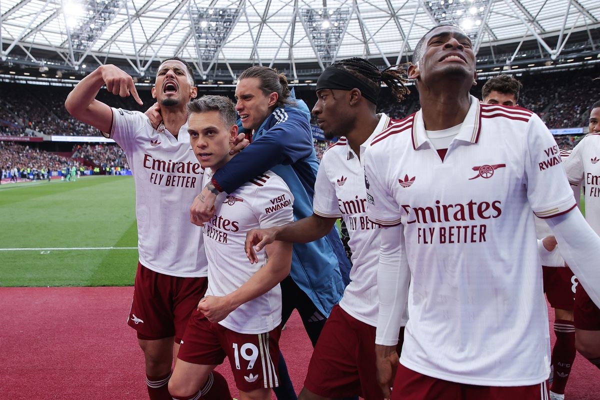 Leandro Trossard celebrates with teammates after scoring their side's first goal during the Premier League match between West Ham United and Arsenal at London Stadium. 