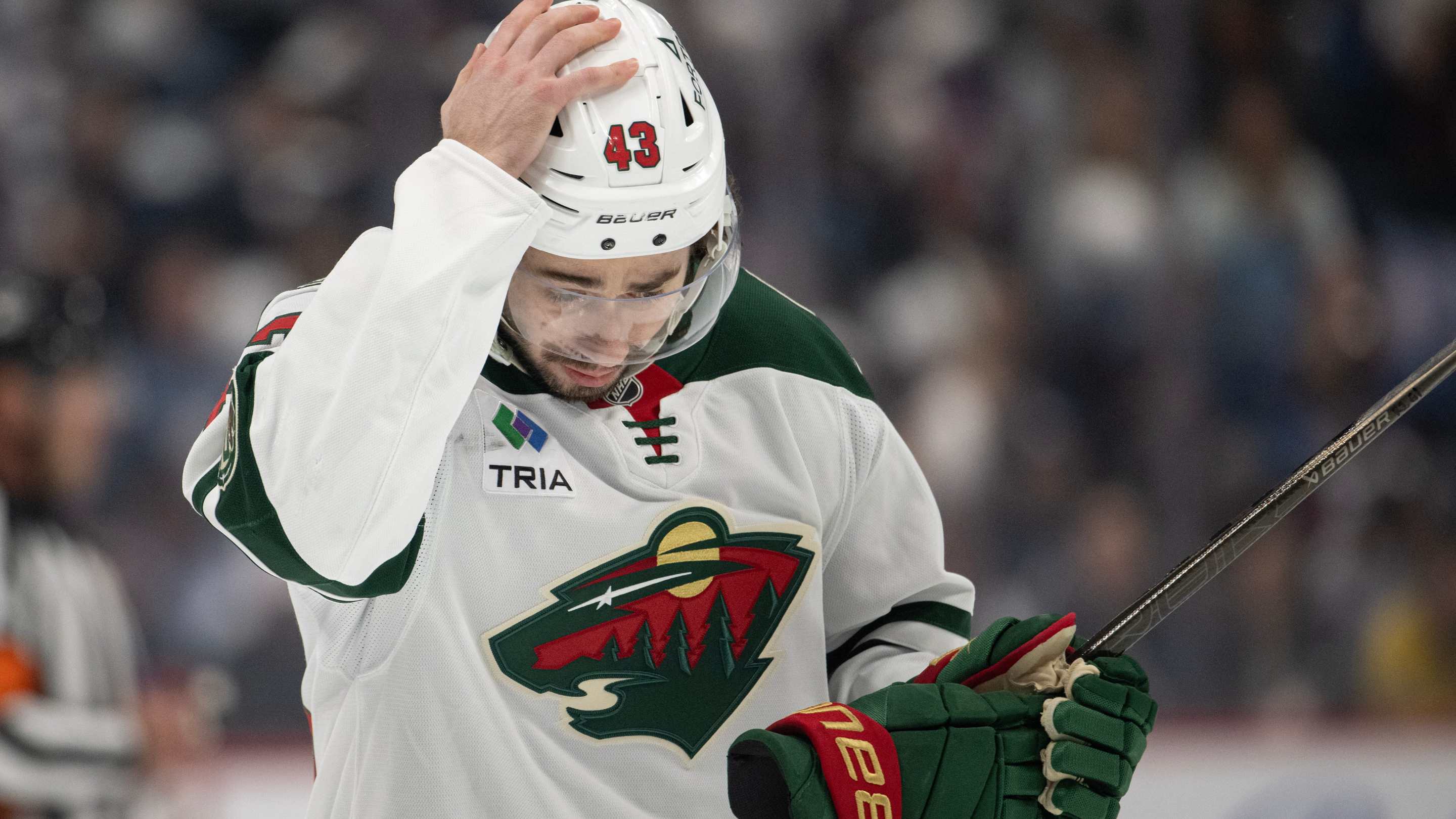 Quinn Hughes pushes his helmet down