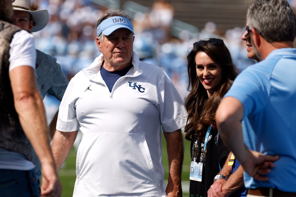 Bill Belichick of the North Carolina Tar Heels and Jordon Hudson watch a football game.