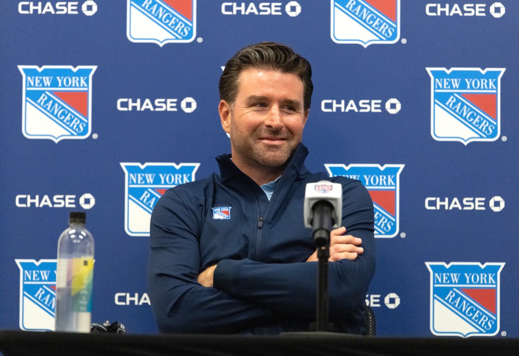 New York Rangers GM Chris Drury smiling during a press conference.
