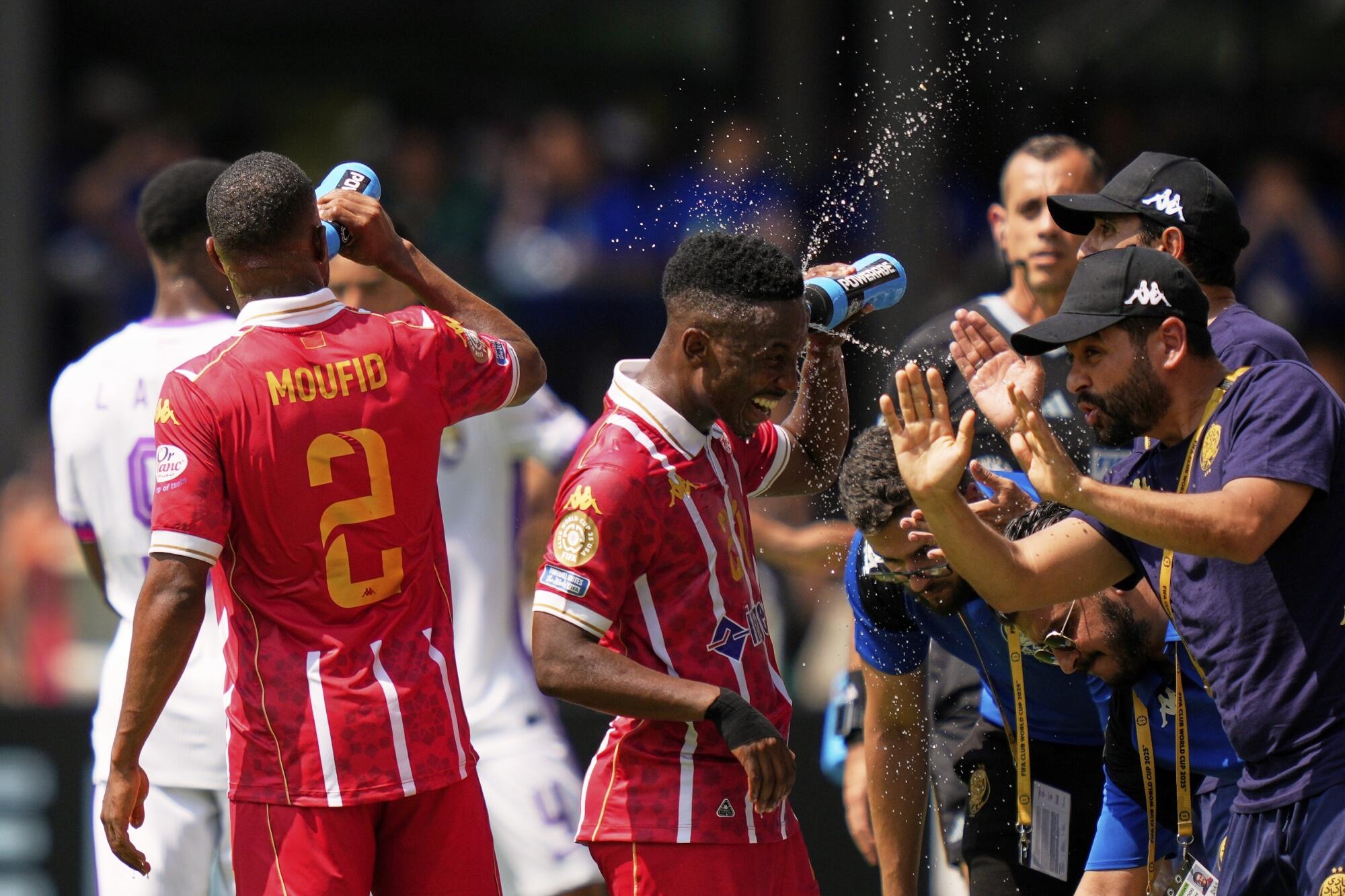 Wydad AC players Cassius Mailula, left, and Mohamed Moufid try to cool off during the Club World Cup.
