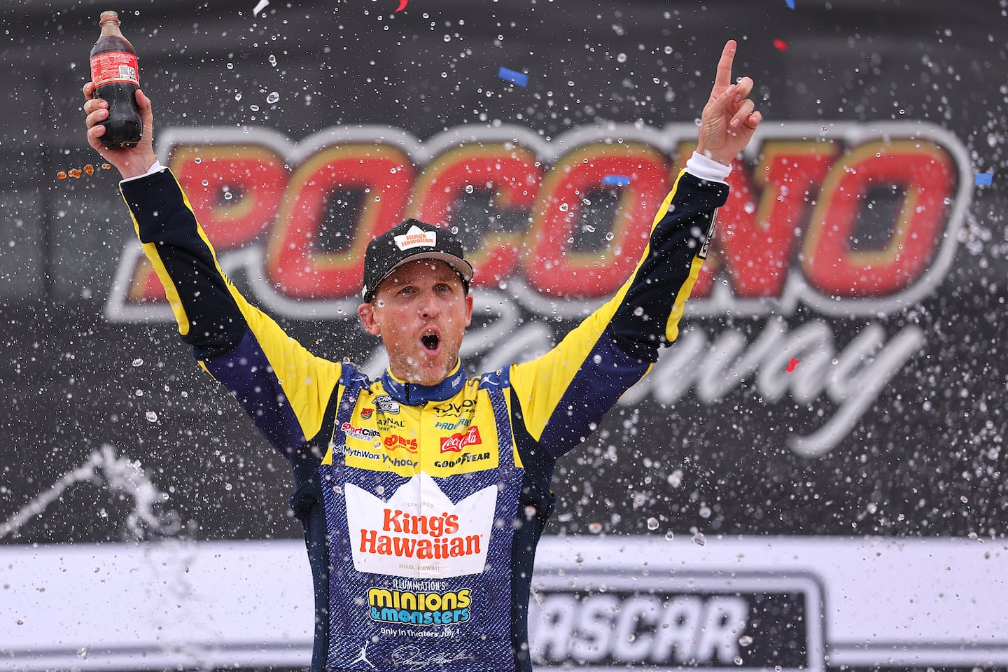 Denny Hamlin celebrates in victory lane after winning at Pocono Raceway.