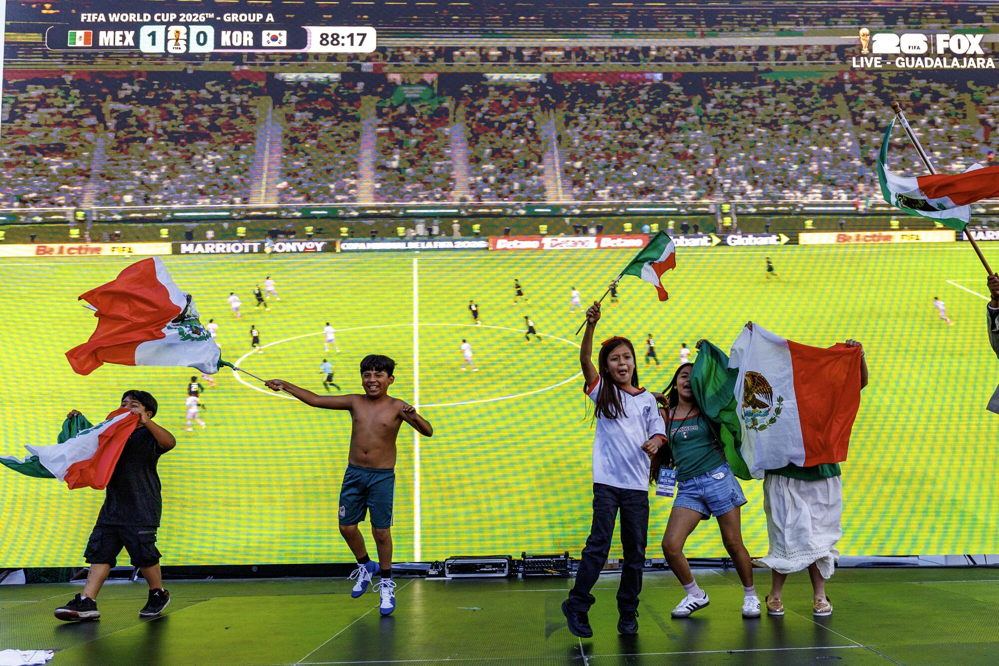Young fans cheer on stage as Mexico is minutes away from a win against Korea during a watch party for the World Cup match.