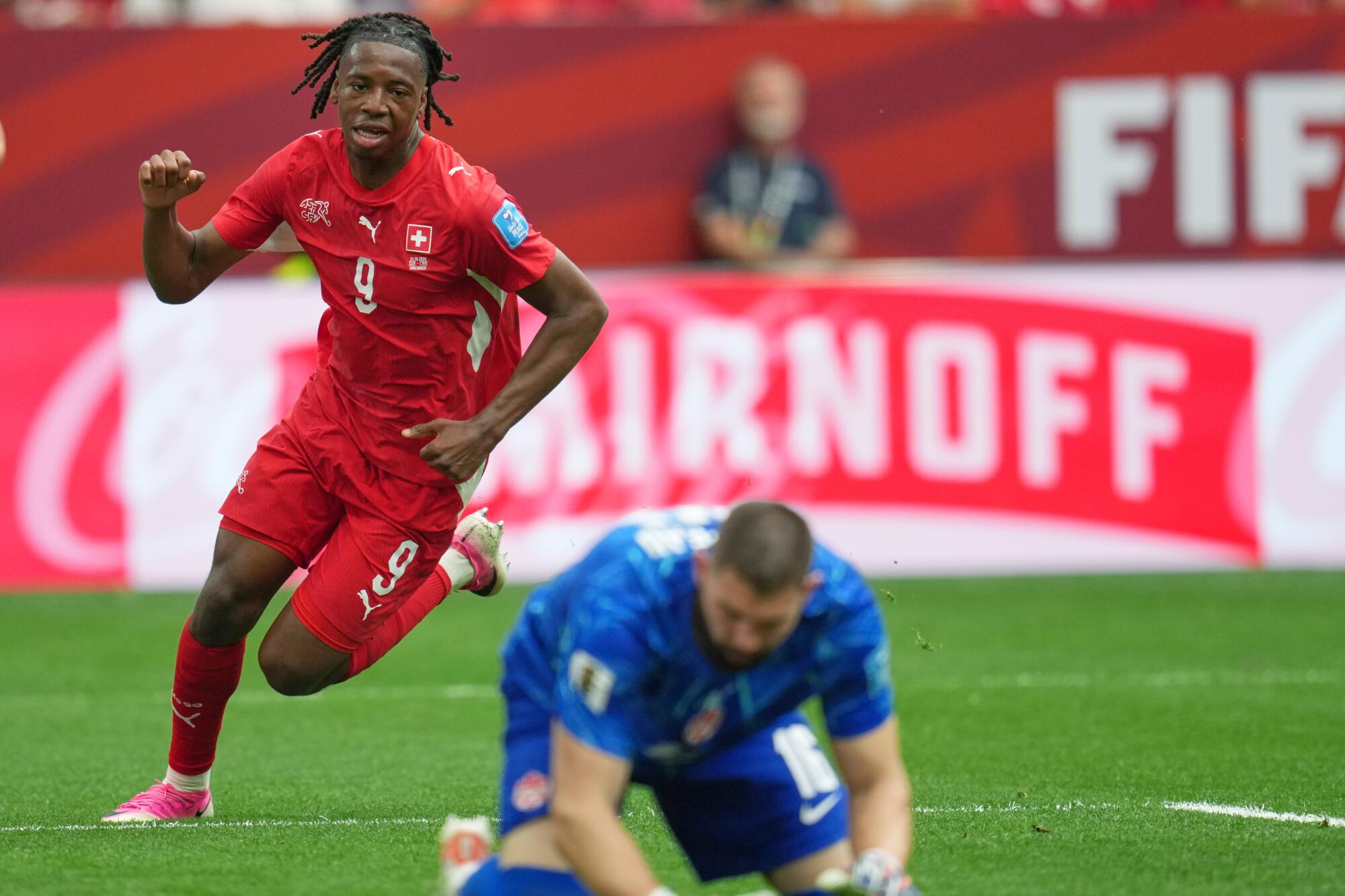 Switzerland's Johan Manzambi celebrates after scoring as Canada goalkeeper Maxime Crepeau bows his head.