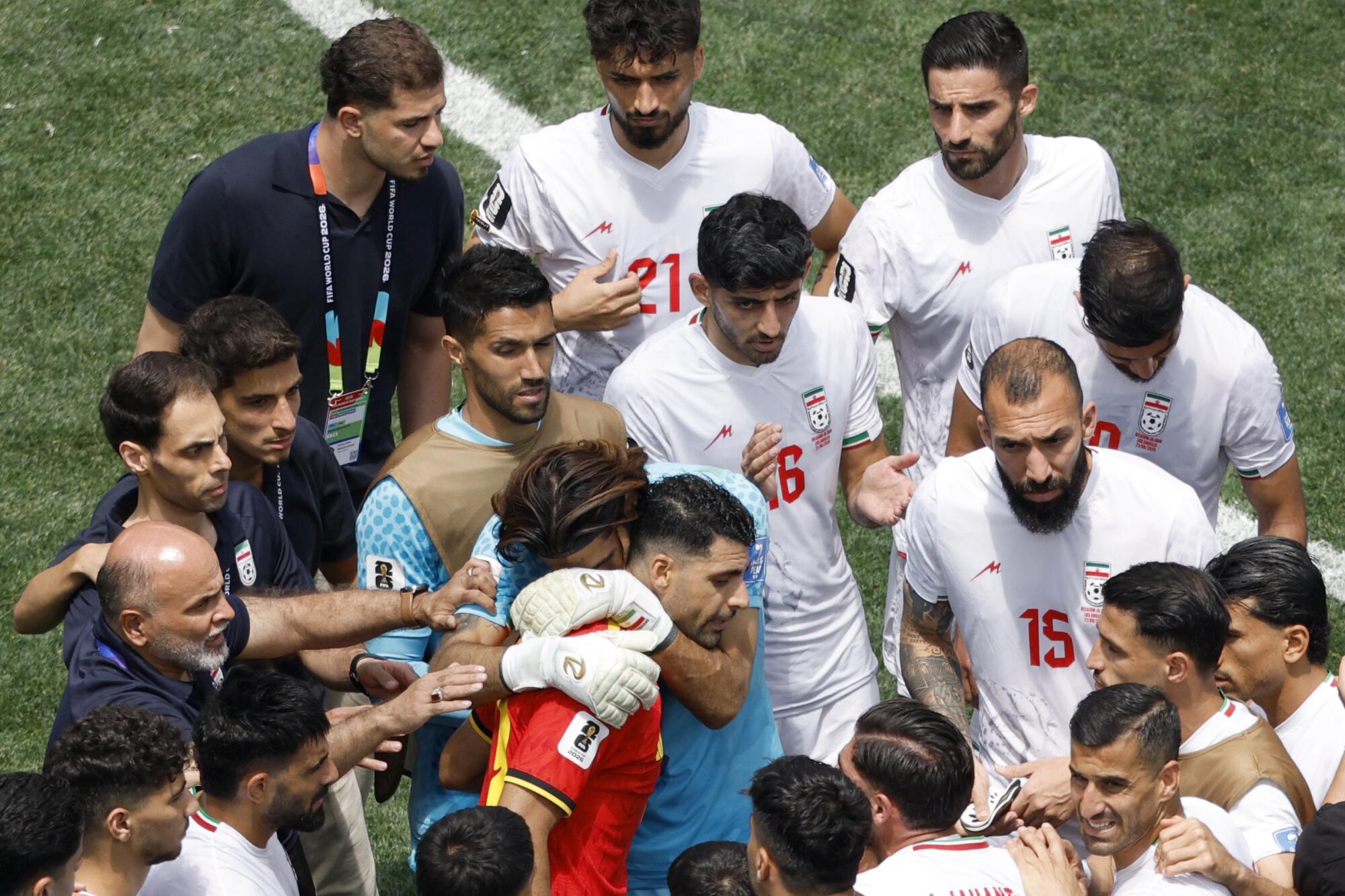Iran goalkeeper Alireza Beiranvand embraces team captain Mehdi Taremi after a 1-1 draw against Belgium.