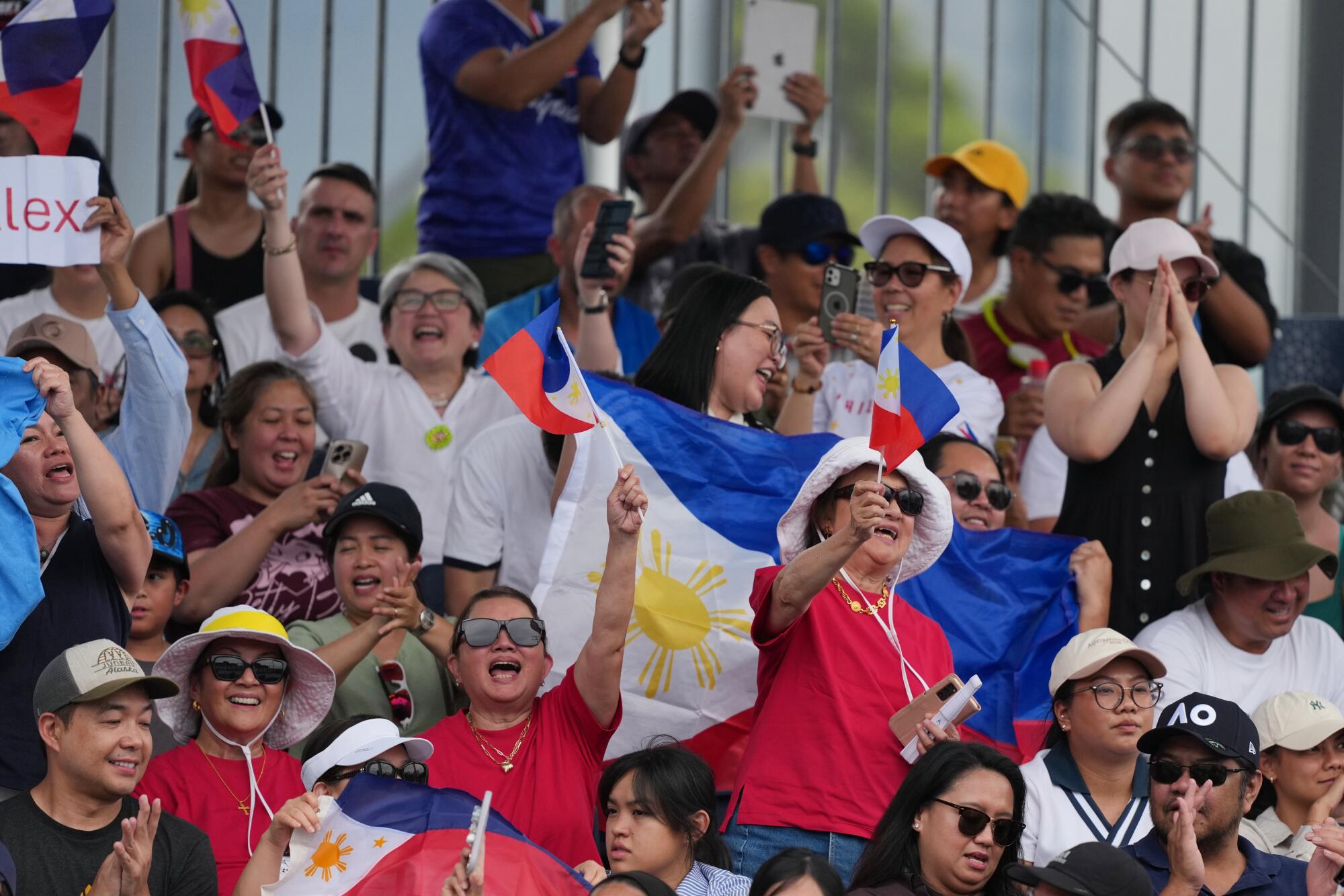Fans wave Phillipines flags while cheering on Alexandra Eala during the Australian Open in Melbourne on Jan. 19.