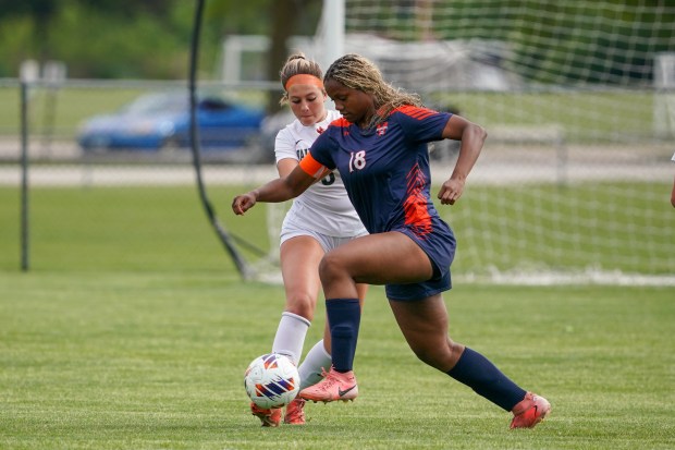 Oswego's Jordyn Washington (18) pushes the ball past Waubonsie Valley's Chloe Shaffer during a Class 3A Oswego Regional semifinal game on Thursday, May 22, 2025. (Sean King / The Beacon-News)