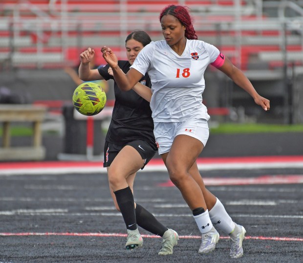 Oswego's Jordyn Washington (18) tangles with Bolingbrook's Cecilia Valdez for the ball during a nonconference game in Bolingbrook on Tuesday, April 28, 2026. (Jon Cunningham / The Beacon-News)