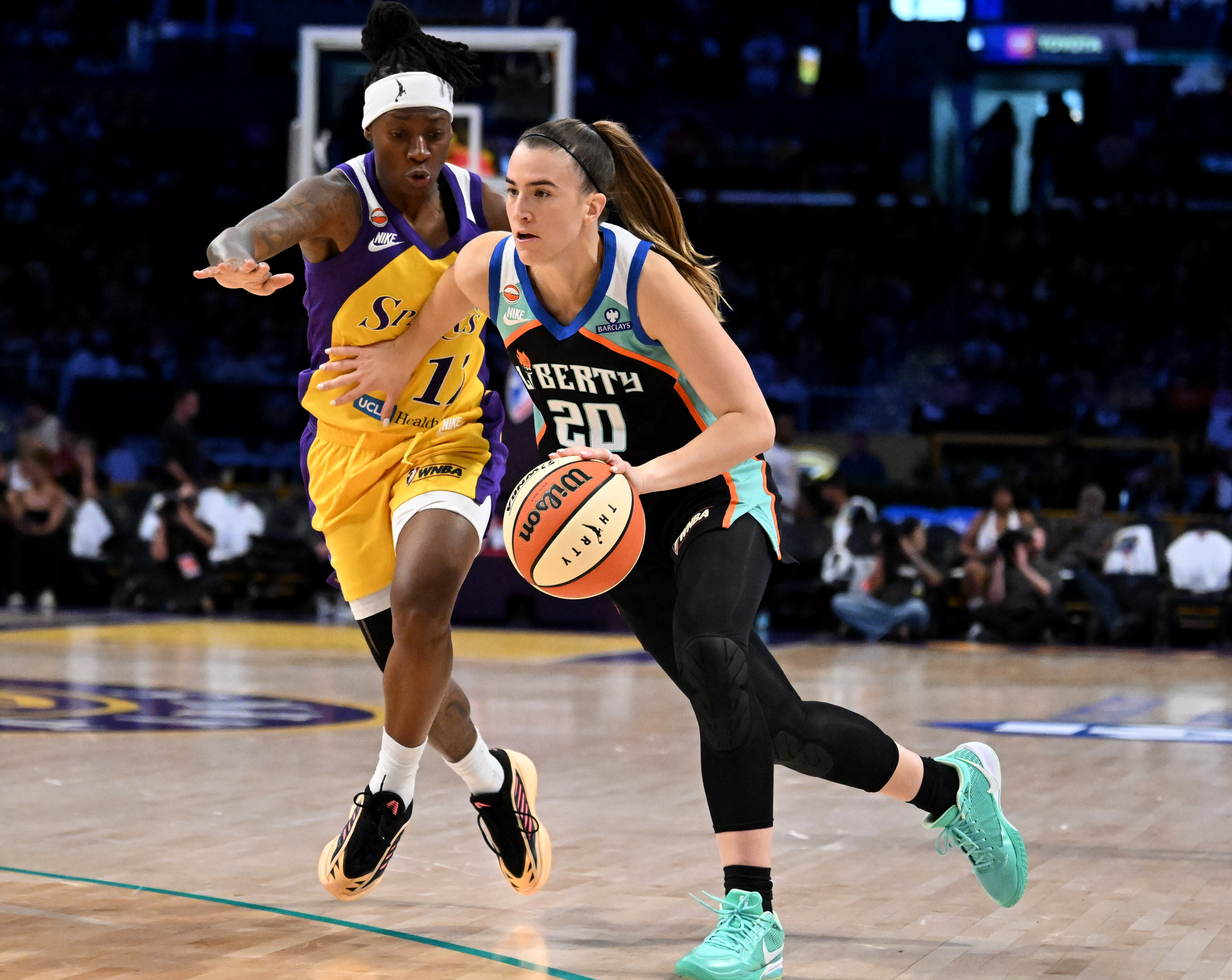 New York Liberty guard Sabrina Lonescu (20) drives past Sparks...