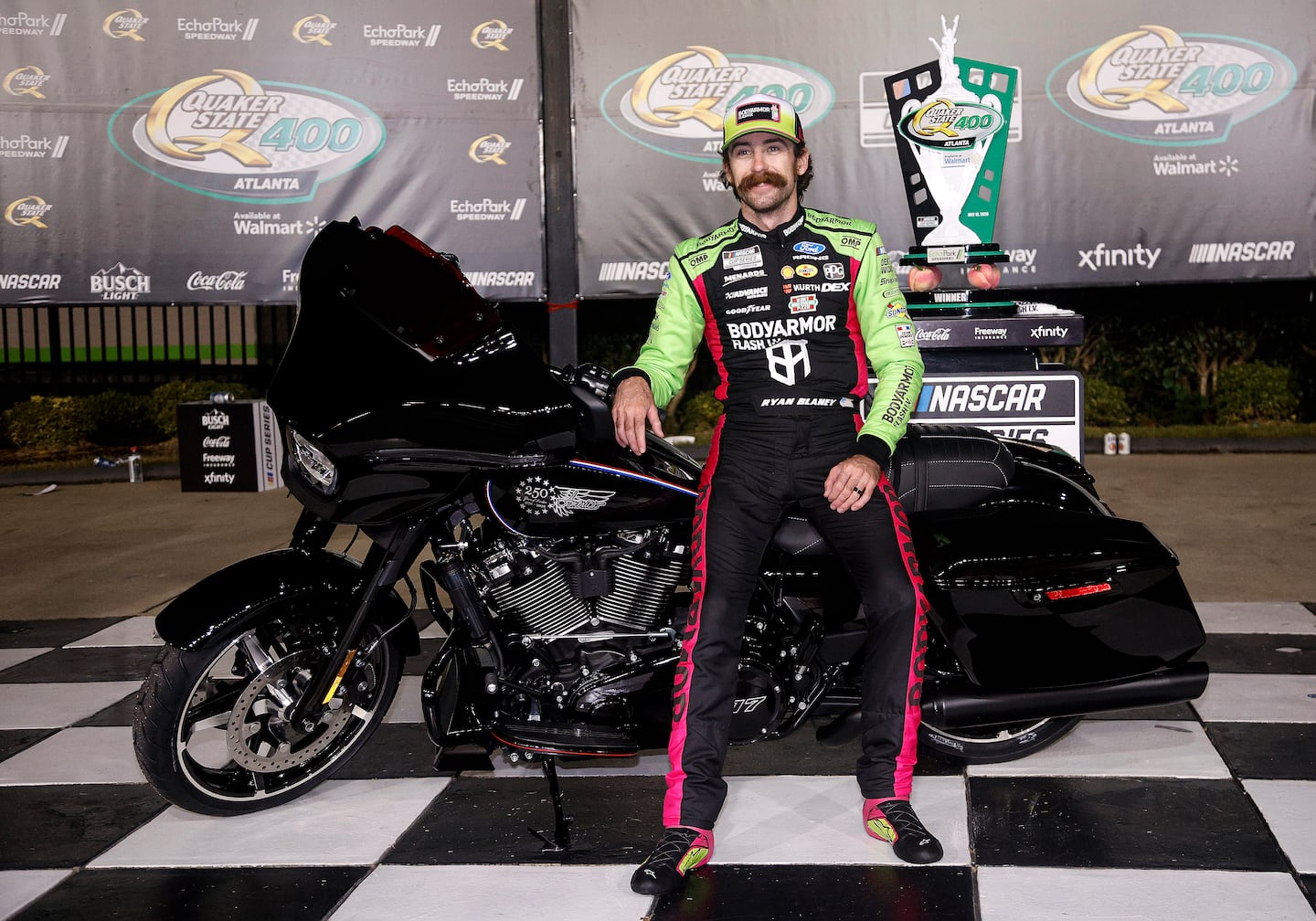 Ryan Blaney poses with a limited-edition Harley-Davidson America 250 motorcycle in victory lane that he earned after winning the NASCAR Cup Series Quaker State 400 Available last weekend in Hampton, Georgia. He's hoping to add some more hardware to his trophy cabinet Sunday night in historic North Wilkesboro, N.C.