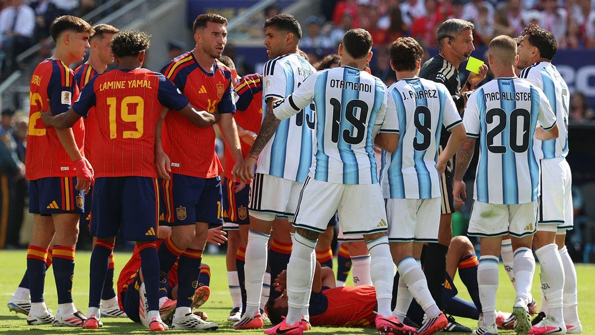 Referee Slavko Vincic shows a yellow card to Leandro Paredes during a soccer match.